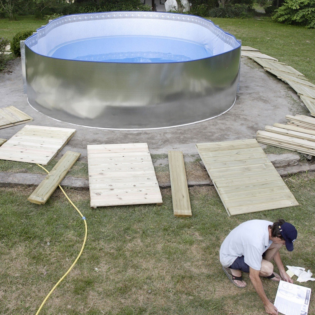 hombre construyendo suelo de piscina desmontable