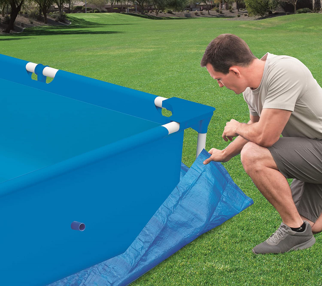 hombre colocando tapiz en suelo de piscina 