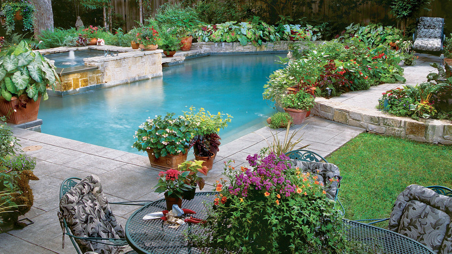 Piscina con macetas y jardines y zona de estar al alrededor